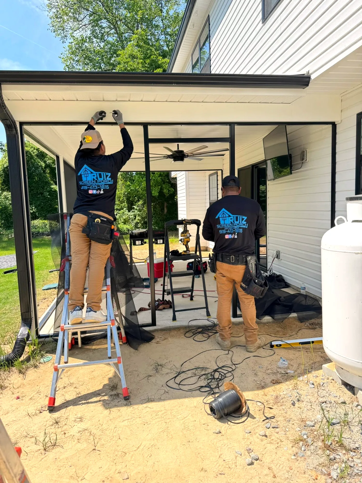 Ruiz Screen crew installing screen panels on a covered patio